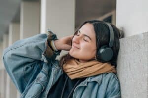 teen wearing headphones listening to music and reaping the benefits of music therapy for anxiety